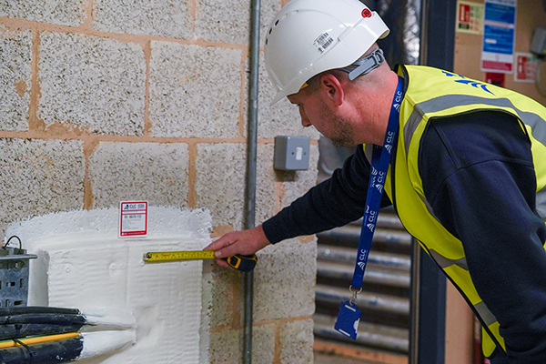 operative completing passive fire works in high vis jacket with a white safety hat
