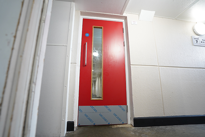 red fire door in a residential block corridor